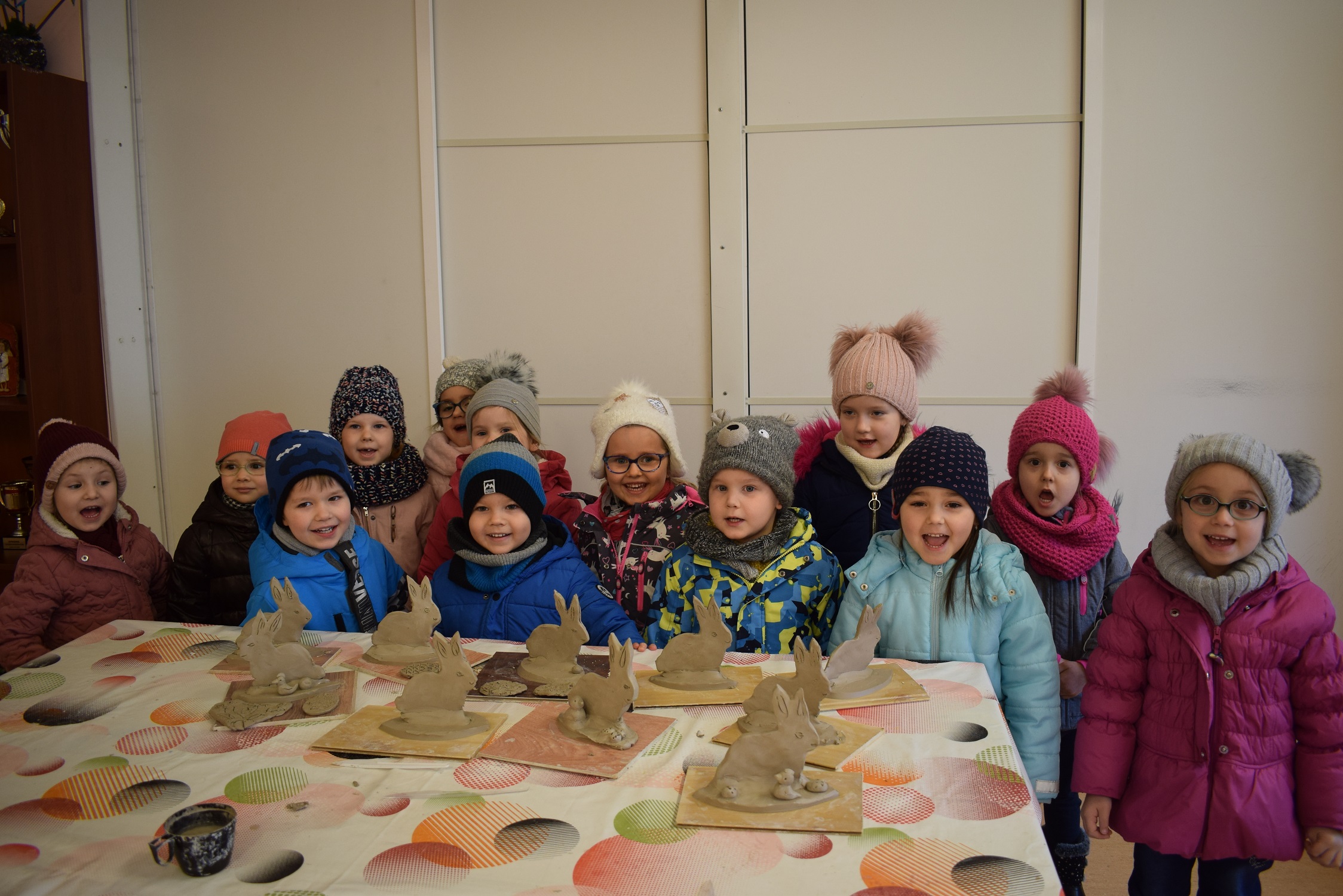 Grupa dzieci ze swoimi glinianymi pracami